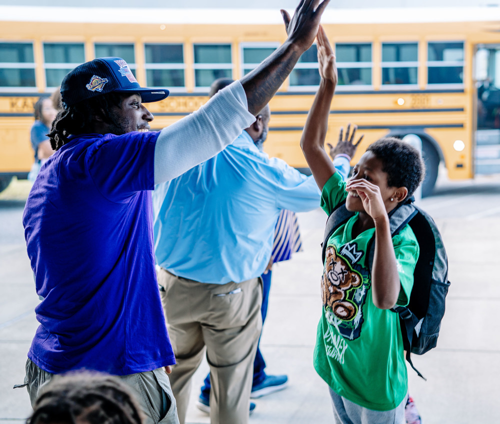 kcs student and teacher high fiving.