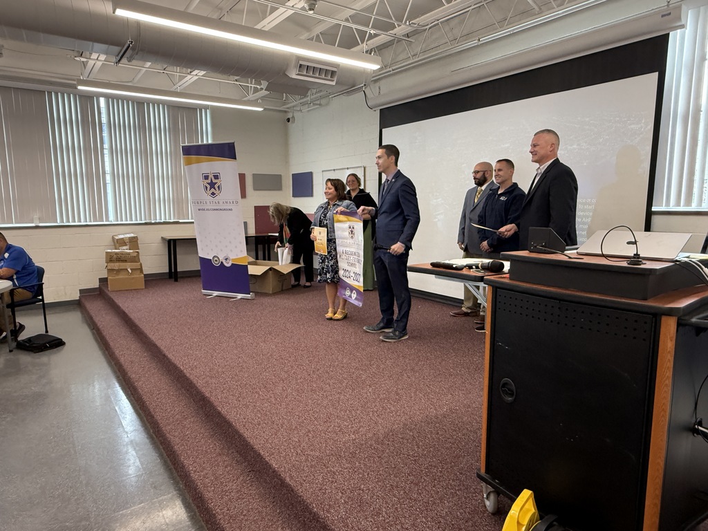 kcs principals accepting their purple star school banner