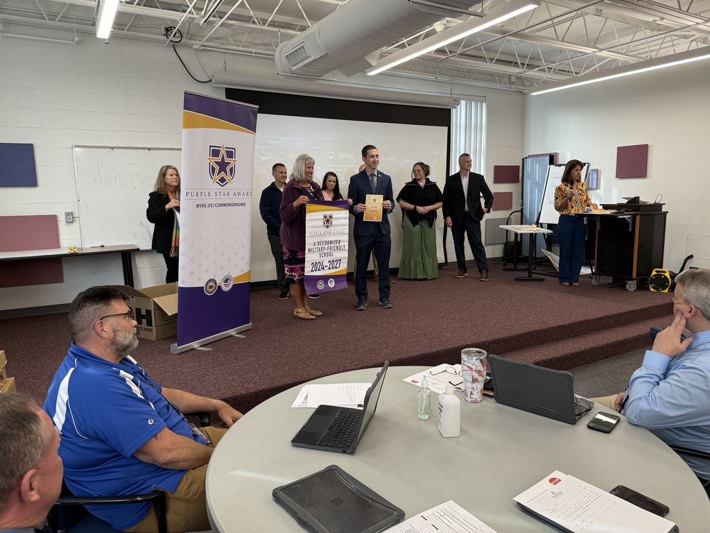 kcs principals accepting their purple star school banner