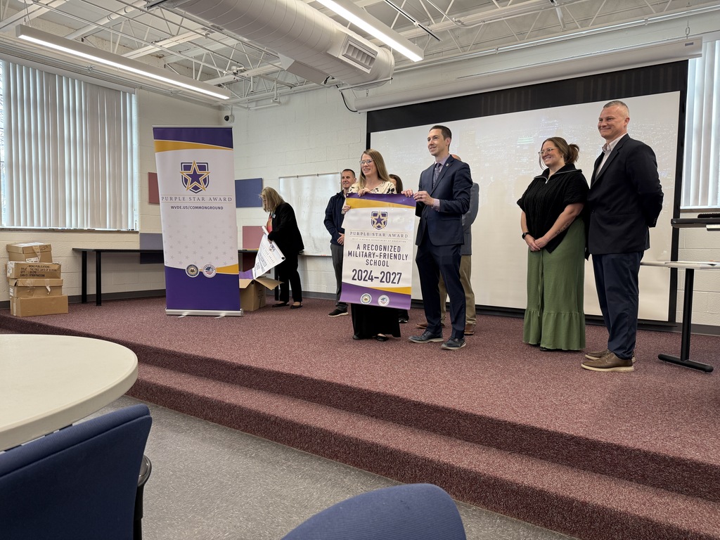 kcs principals accepting their purple star school banner