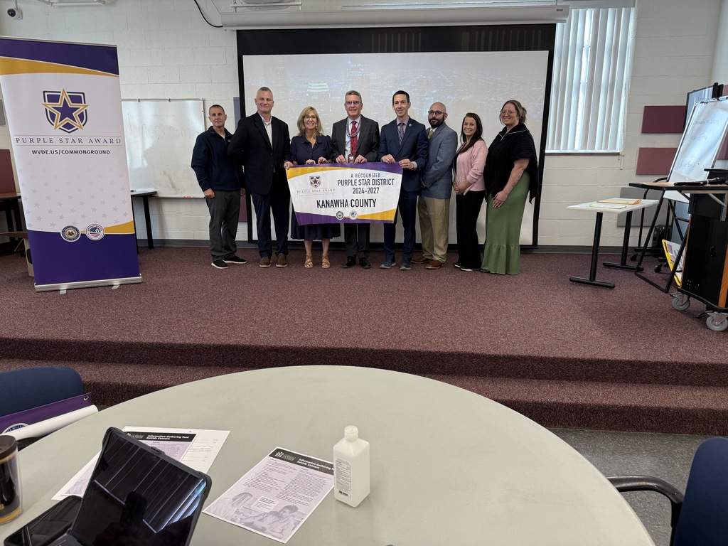 kcs principals accepting their purple star school banner