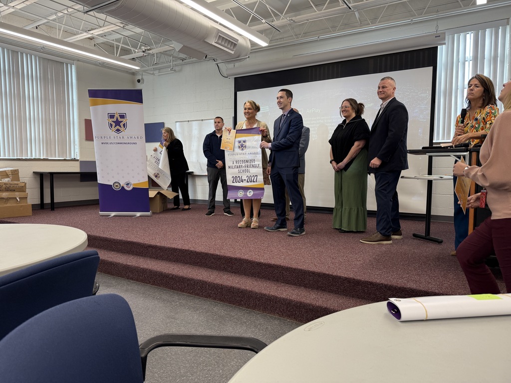 kcs principals accepting their purple star school banner