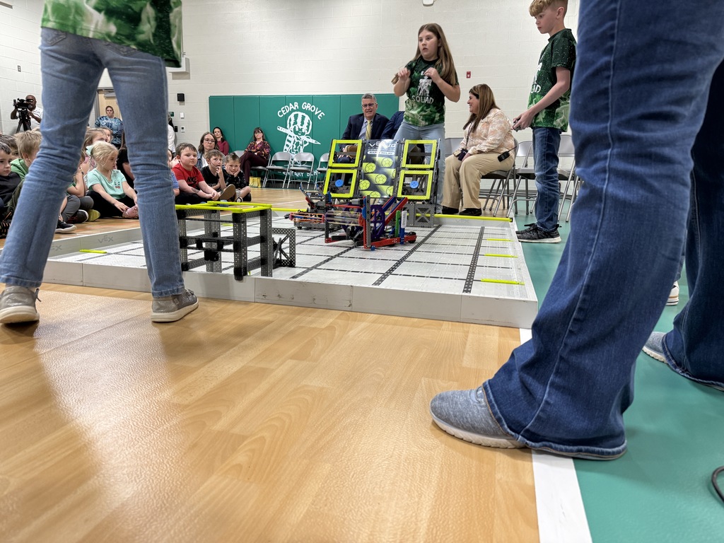 the bot squad practicing with their robots in the school gym