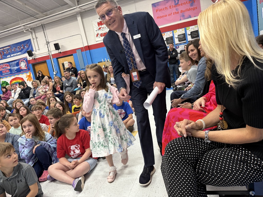 pinch elementary student escorting dr. williams to the podium to deliver his remarks to pinch students and guests