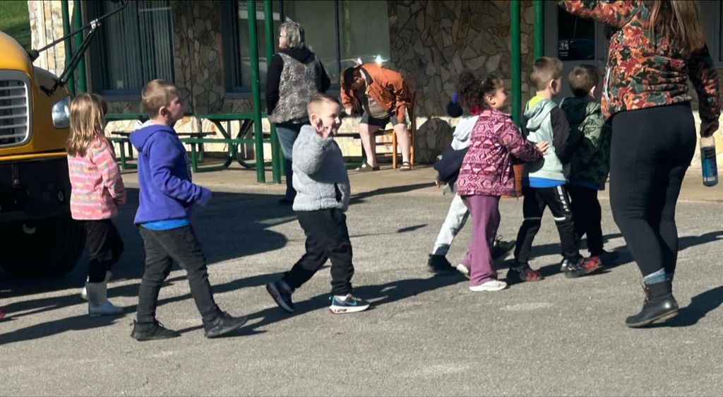 alum creek student waving hello after getting off of the school bus.
