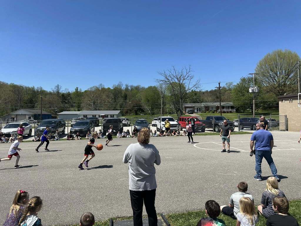 third grade students at sissonville elementary playing school staff in a basketball game at school.