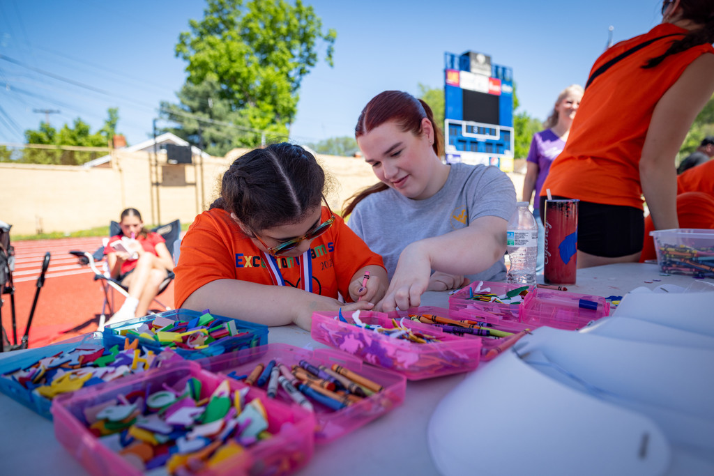 a student coloring a picture at the craft tent at the exceptional spring games.