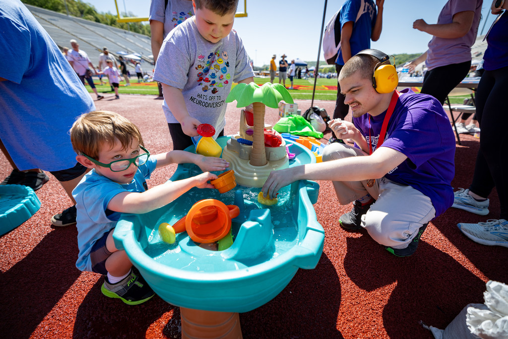 students at the spring games playing with a water table.