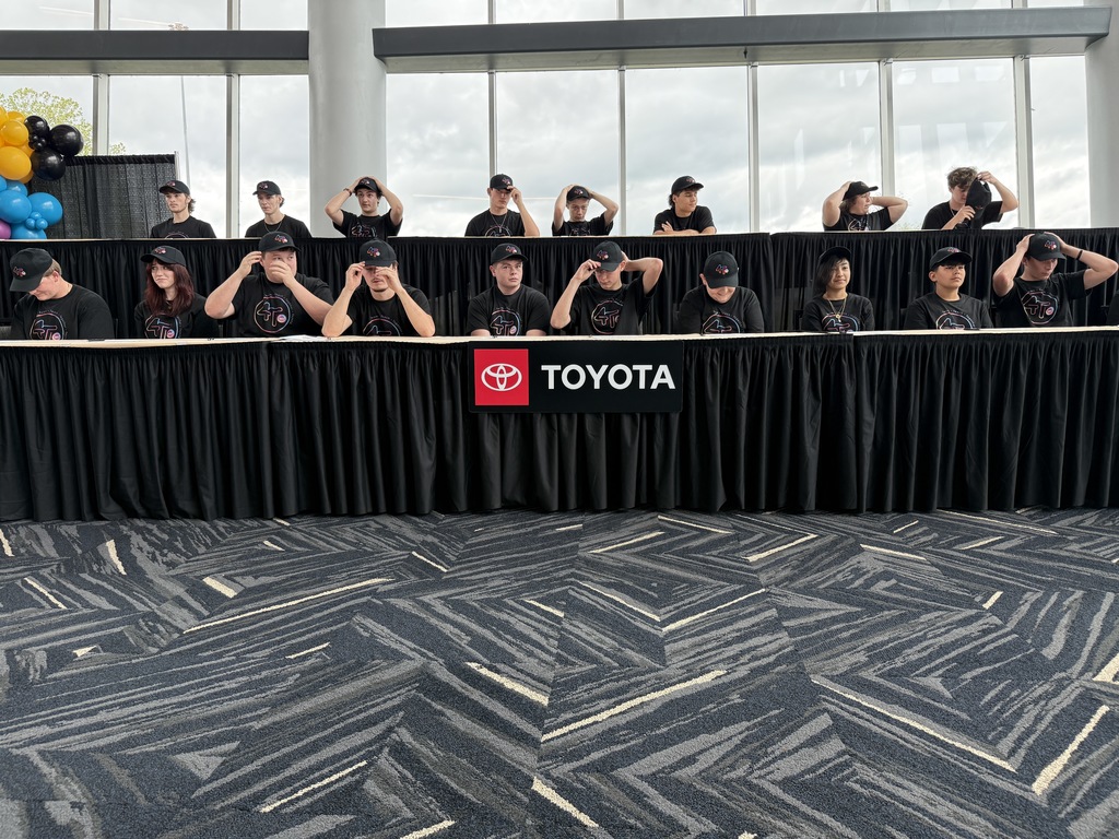 4T Academy students putting on their 4T hats after signing their offer letter into the program.