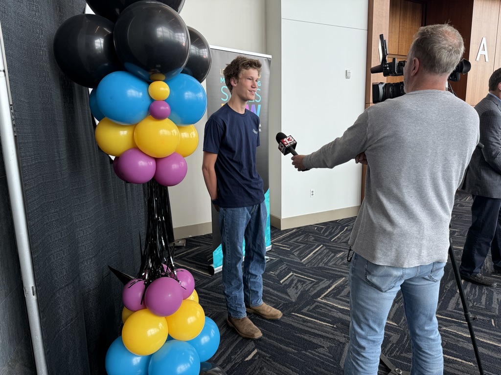 current 4T student being interviewed by the news during the signing ceremony.