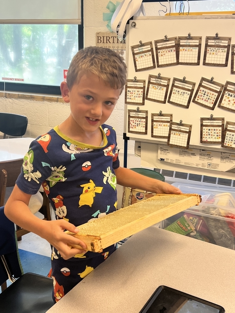 belle elementary student holding a honeycomb from a local beekeeper.