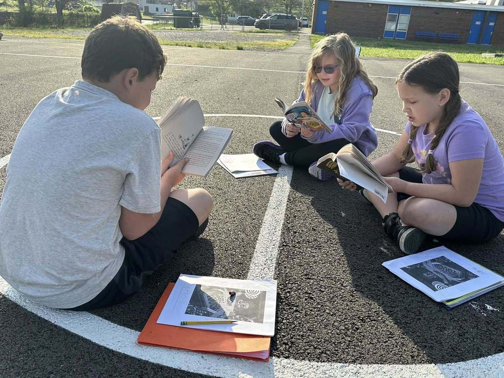 alum creek students reading on the playground.