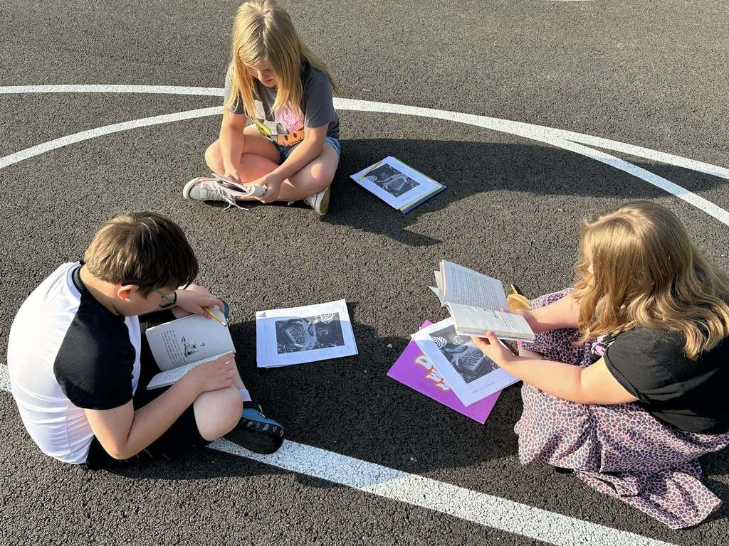 alum creek students reading on the playground.