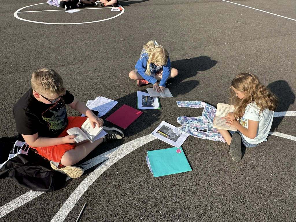alum creek students reading on the playground.