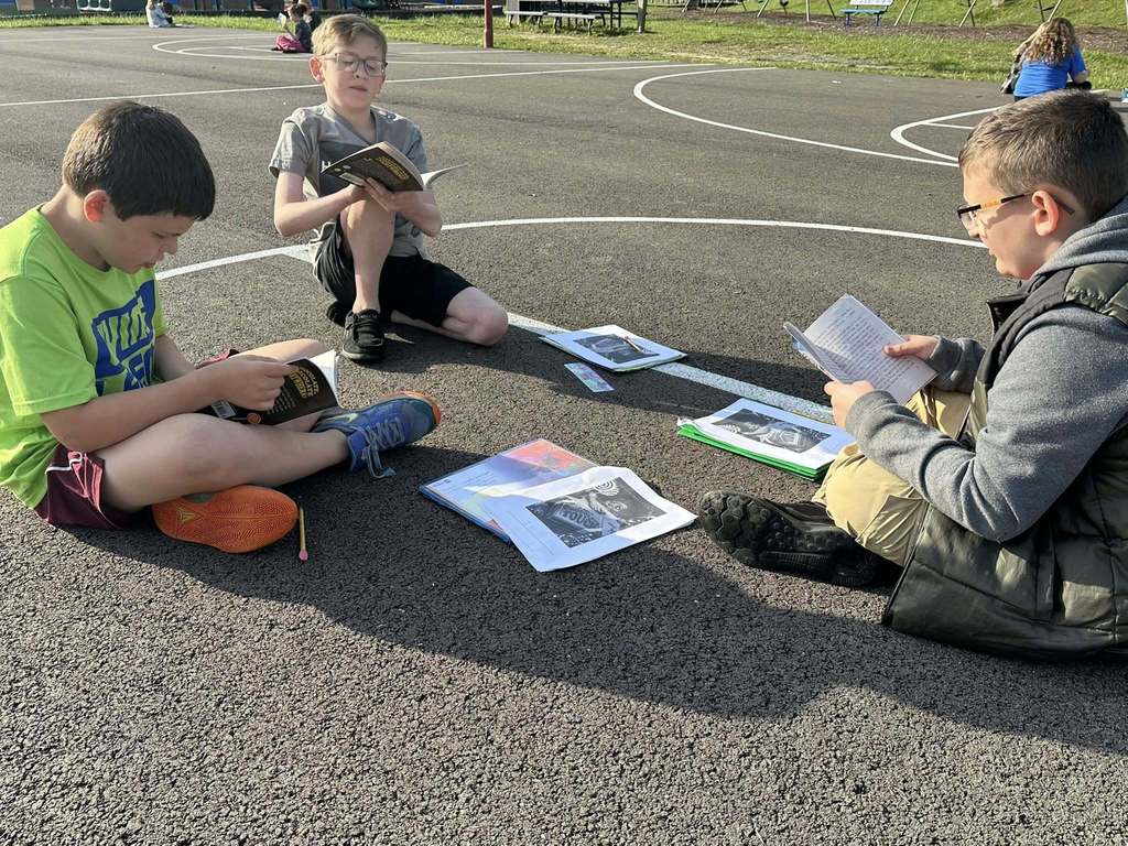 alum creek students reading on the playground.