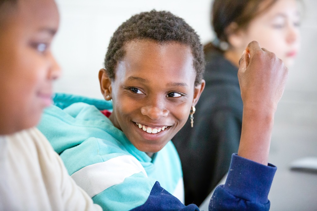 students smiling during a computer lesson at school.