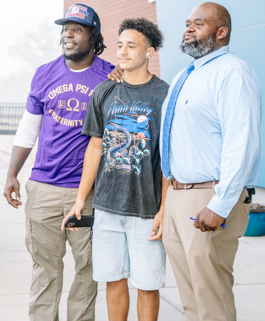 high school student posing with administrators on the first day of school. 