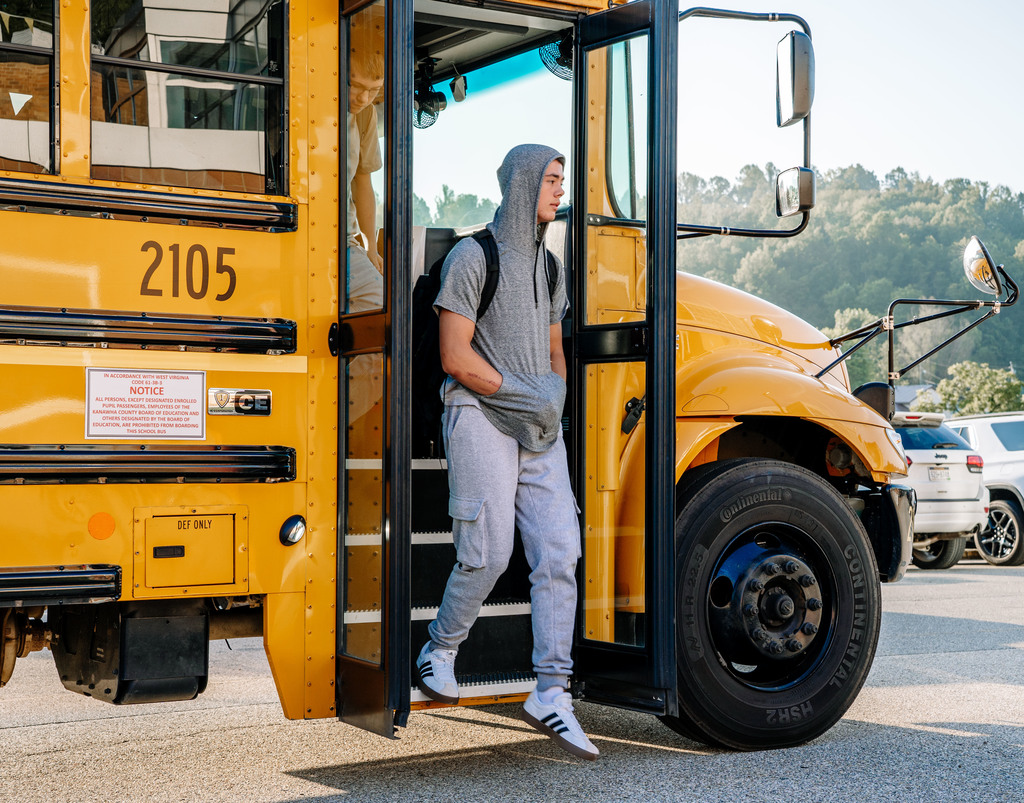 student getting off the bus on the first day of school.
