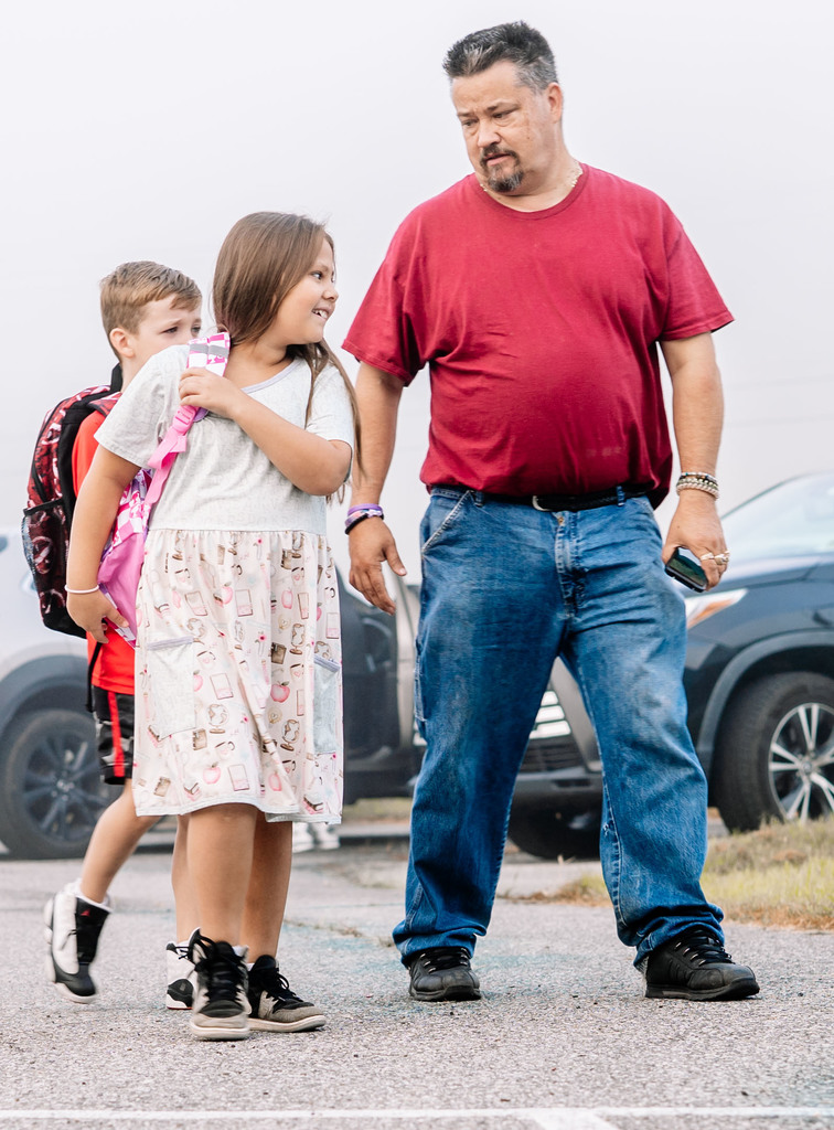 father and daughter walking into school.