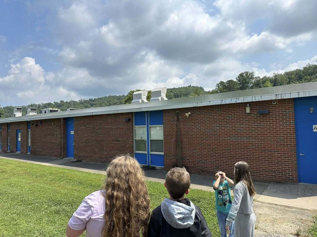 students at alum creek looking at the clouds in the sky as part of their science lesson.