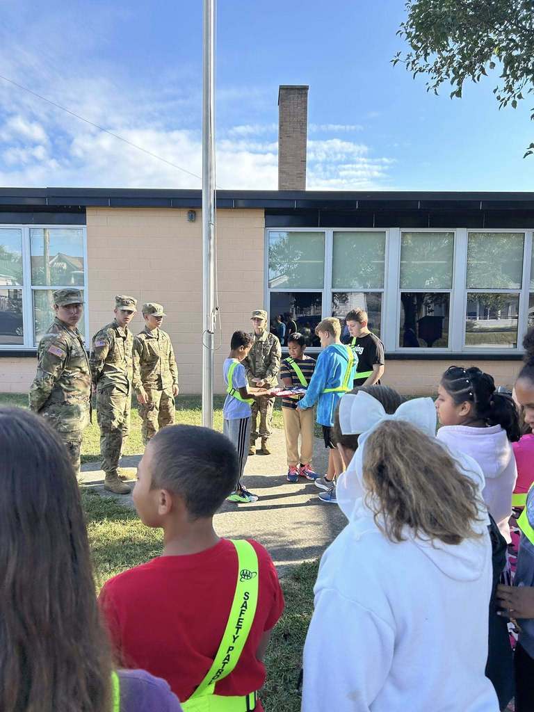 nes students practicing folding the american flag while nhs rotc students look on.
