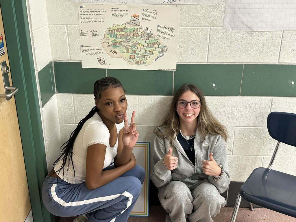 two capital high school students showing the rights and laws of the island country they created for a civics lesson.