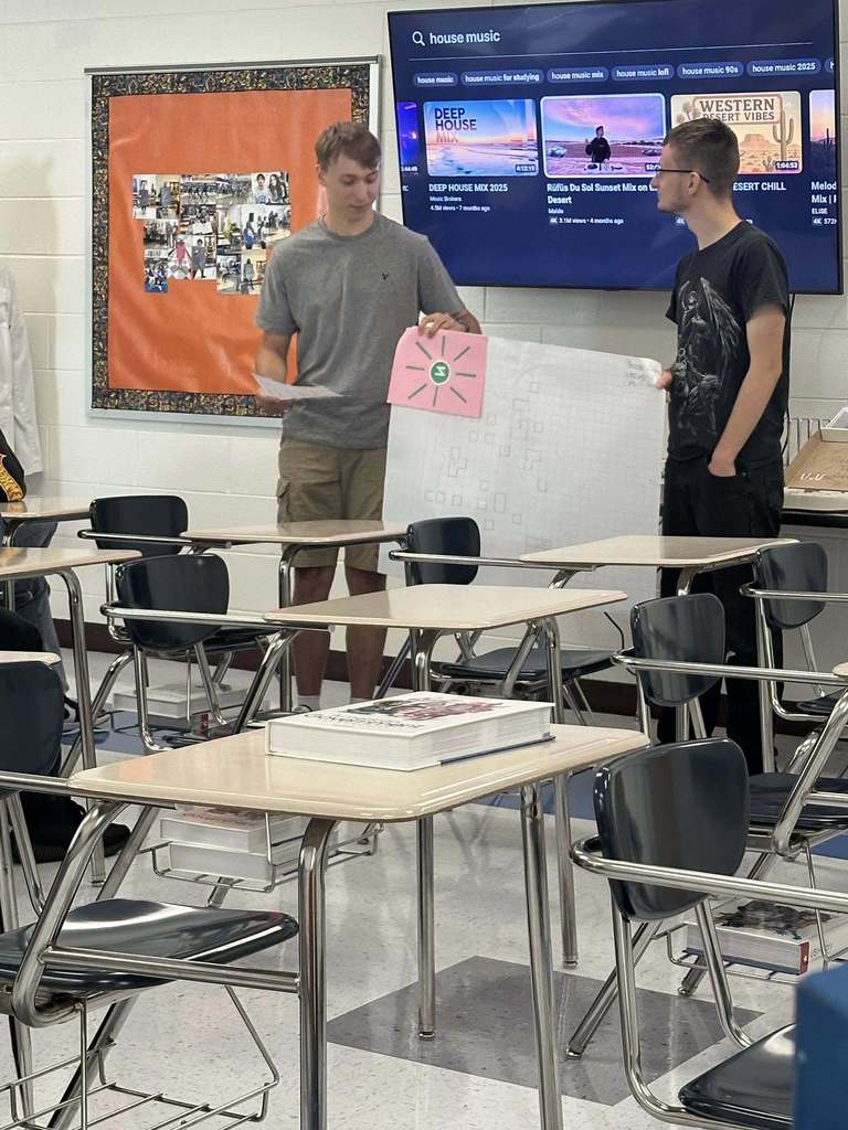 two capital high school students presenting the rights and laws of their new country they made during a civics class.