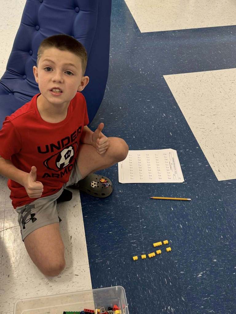 student in the process of building his lego car.