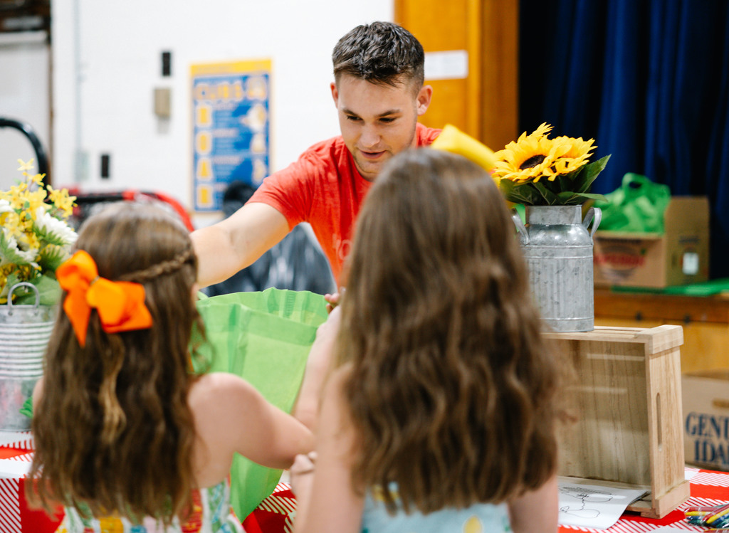 wv harvest employee handing bags to malden students so they can take food home from the school's farmers market event.