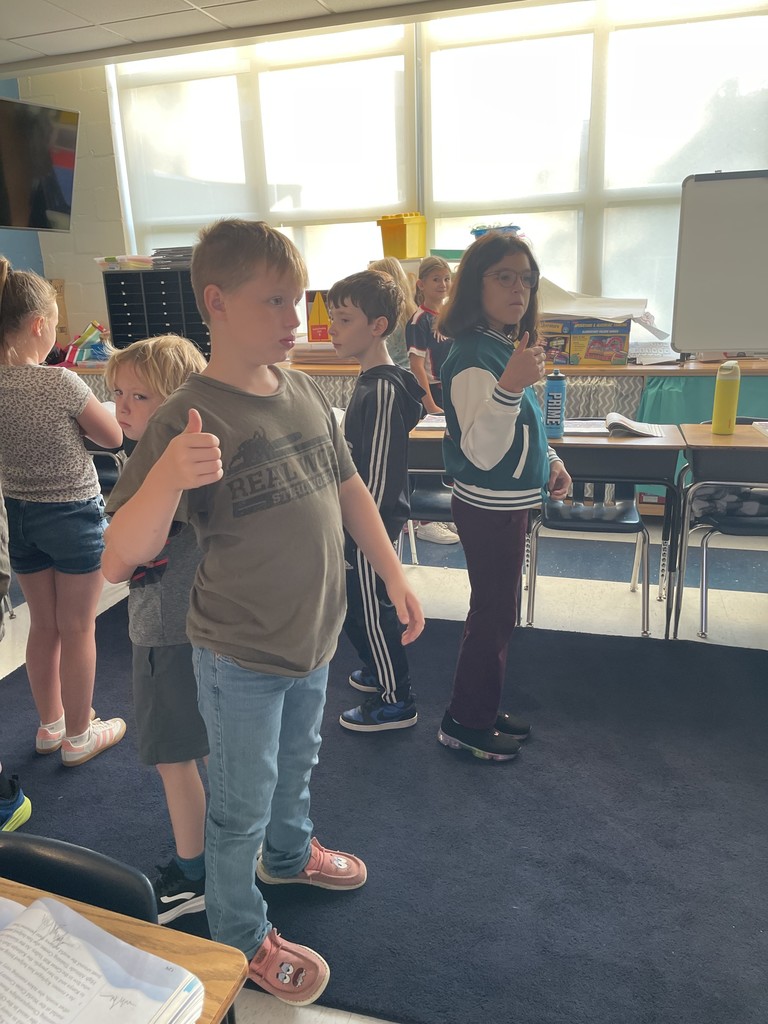 students standing with their back to each other as the lesson gets started.
