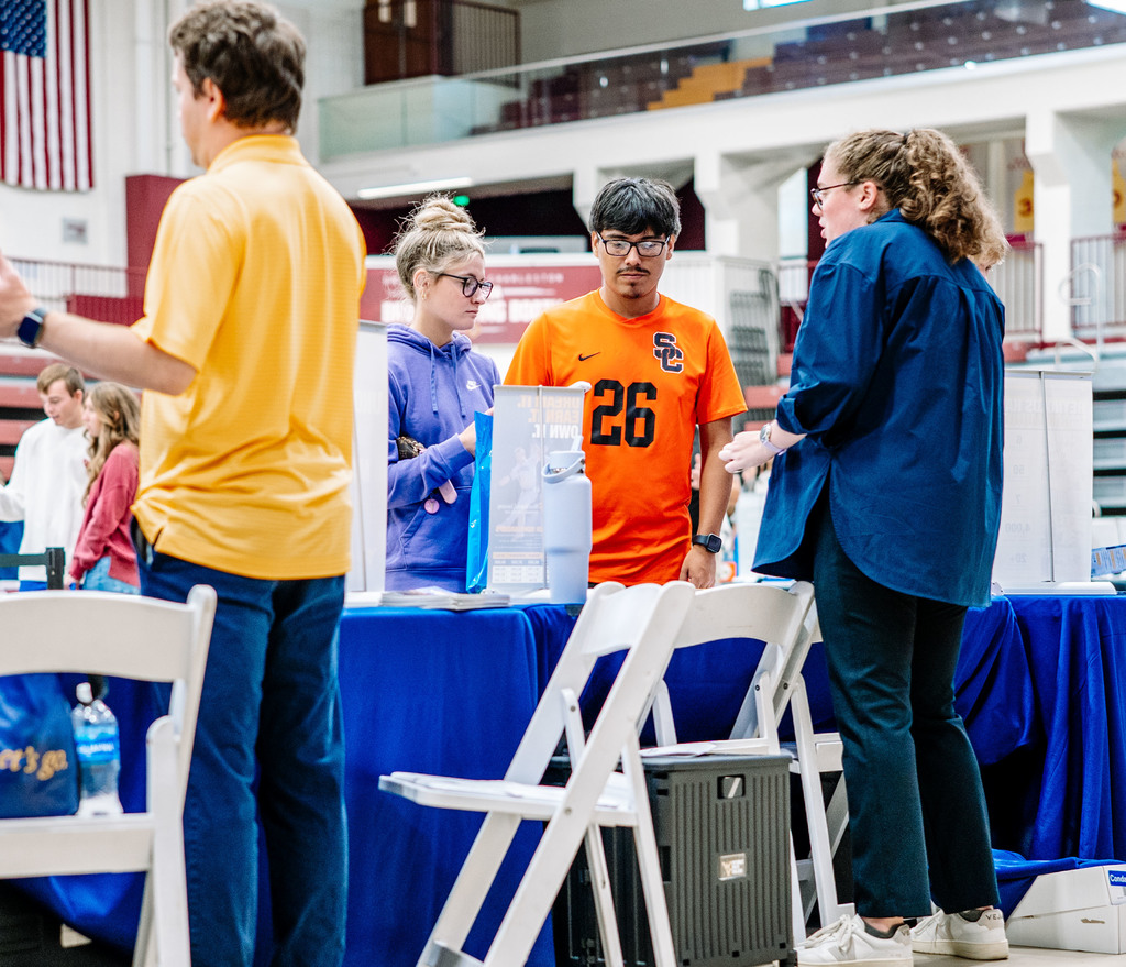 two students speaking with a representative from west virginia university.