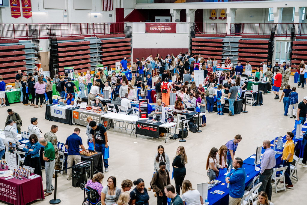 hundreds of students walking around the university of charleston gymnasium talking with recruiters from 52 universities, colleges, and other post-secondary institutions. 