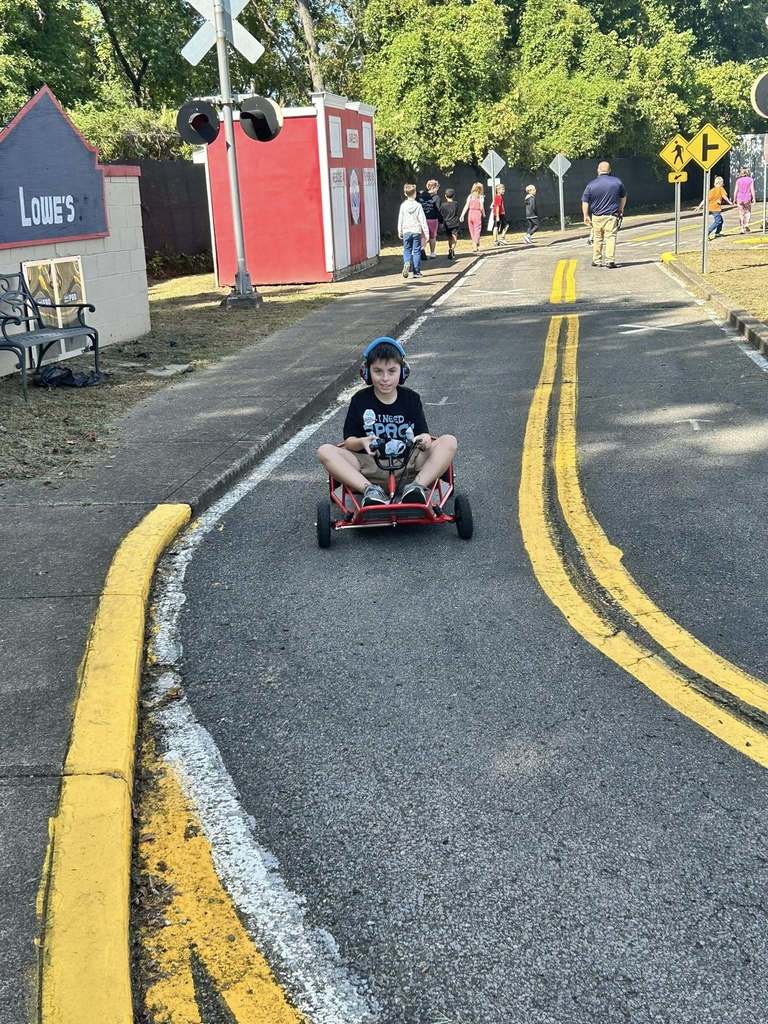 student driving a go kart at safety city. 
