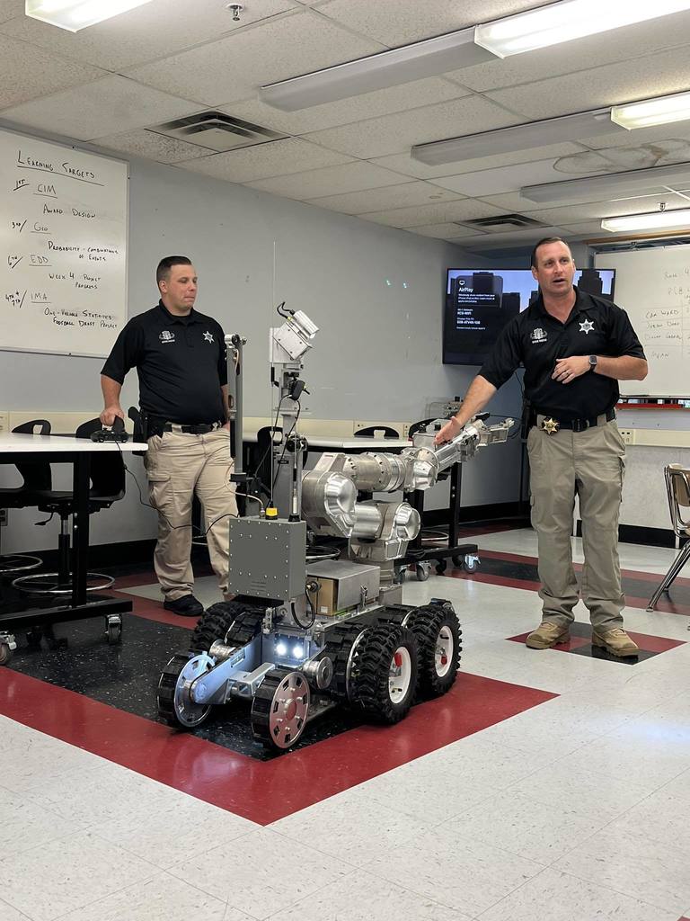 two kanawha county deputies showing how the robot used by the bomb squad works. 