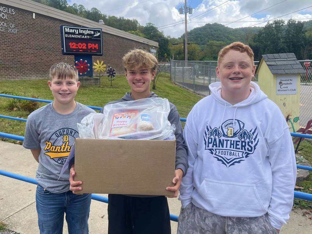 DuPont middle school students dropping off cake kits to the school in their feeder area. 