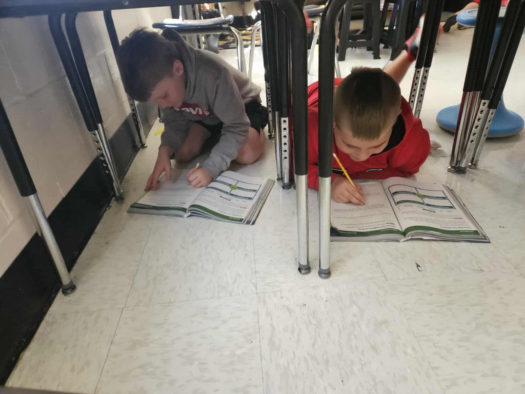 students at nitro elementary reading their books under their desks.