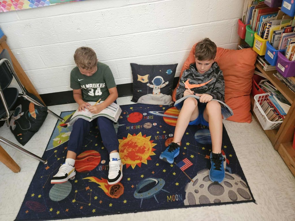 students at nitro elementary reading their books under their desks.