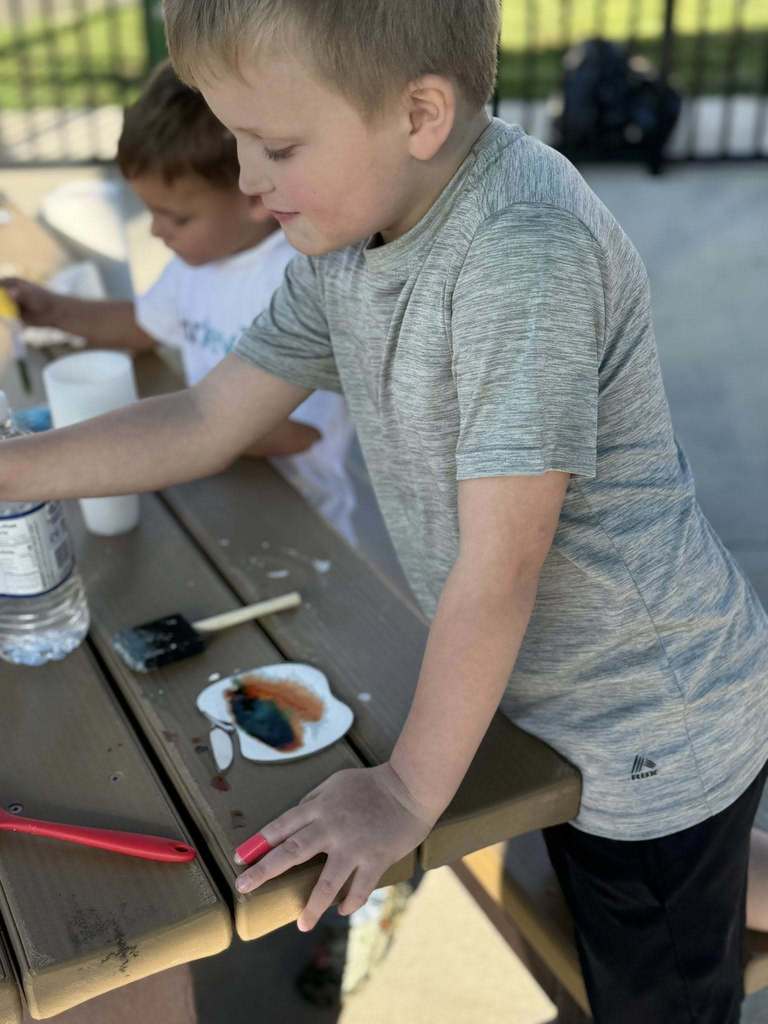 a student reaching for a pumpkin.