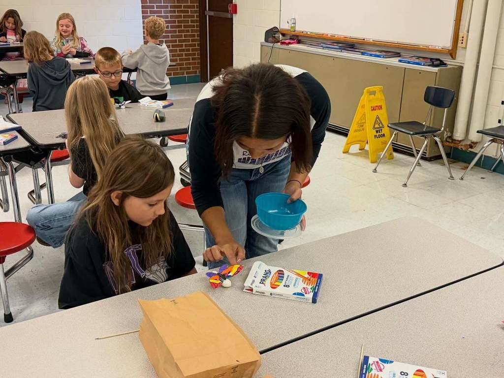 a riverside student working with a midland trail student to build a 3D butterfly.
