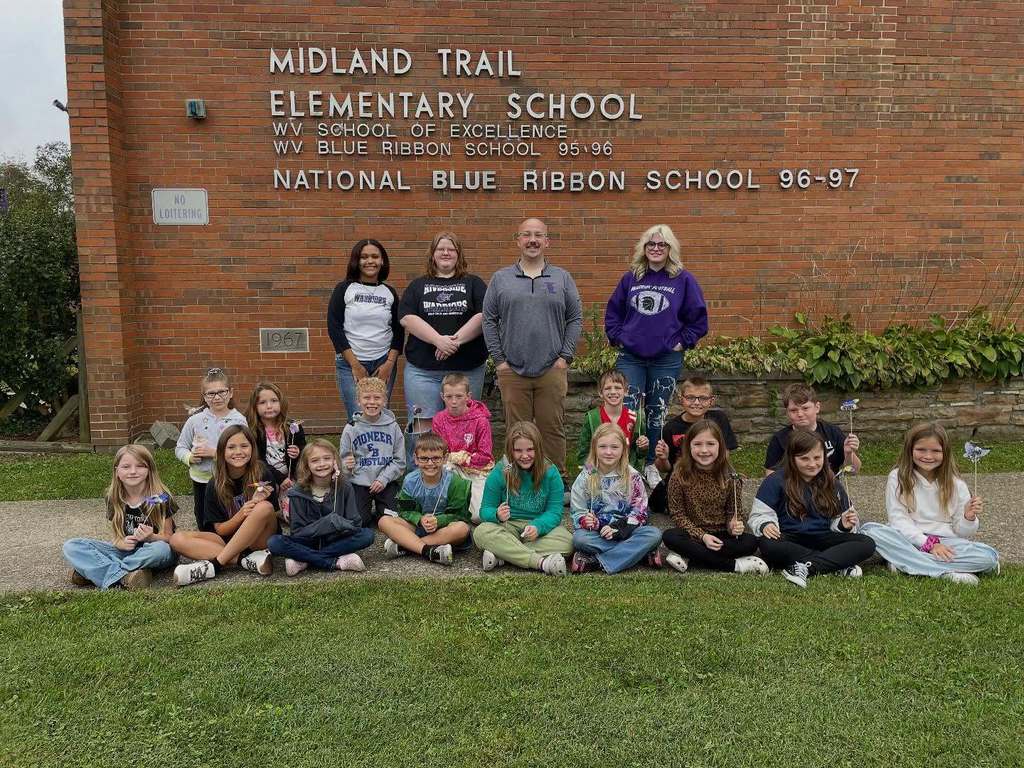 riverside high school art students and midland trail 3rd grade students posing for a picture outside of the school showing off their 3D butterflies.