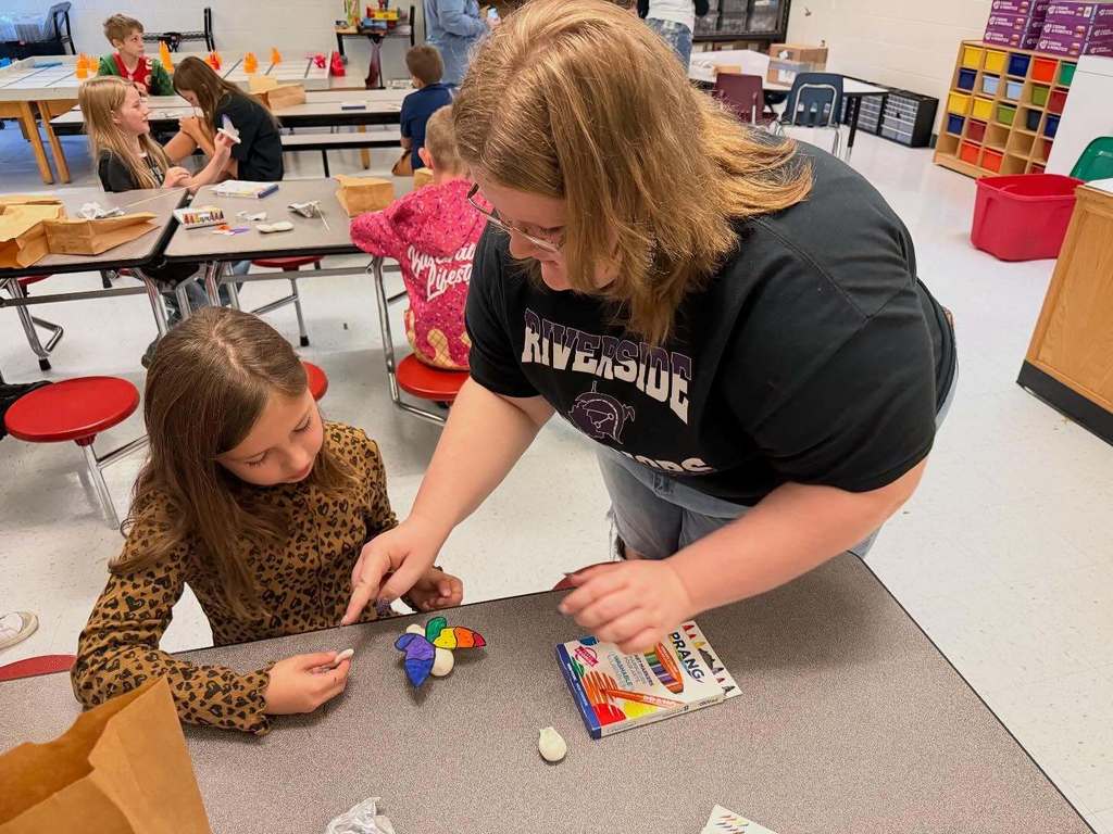 a riverside student working with a midland trail student to build a 3D butterfly.