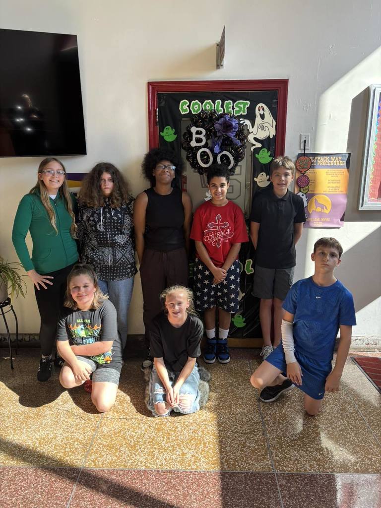 west side middle school student council members posing for a picture in a school hallway they decorated for homecoming week.