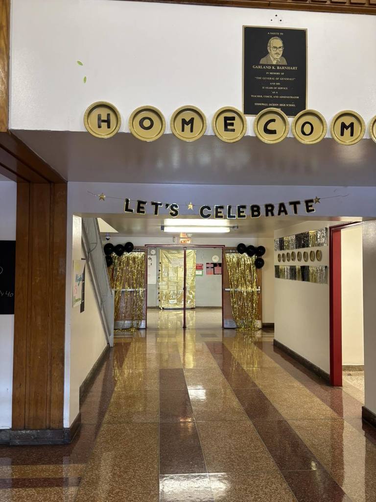 a hallway at west side middle school decorated with gold and black homecoming decorations.