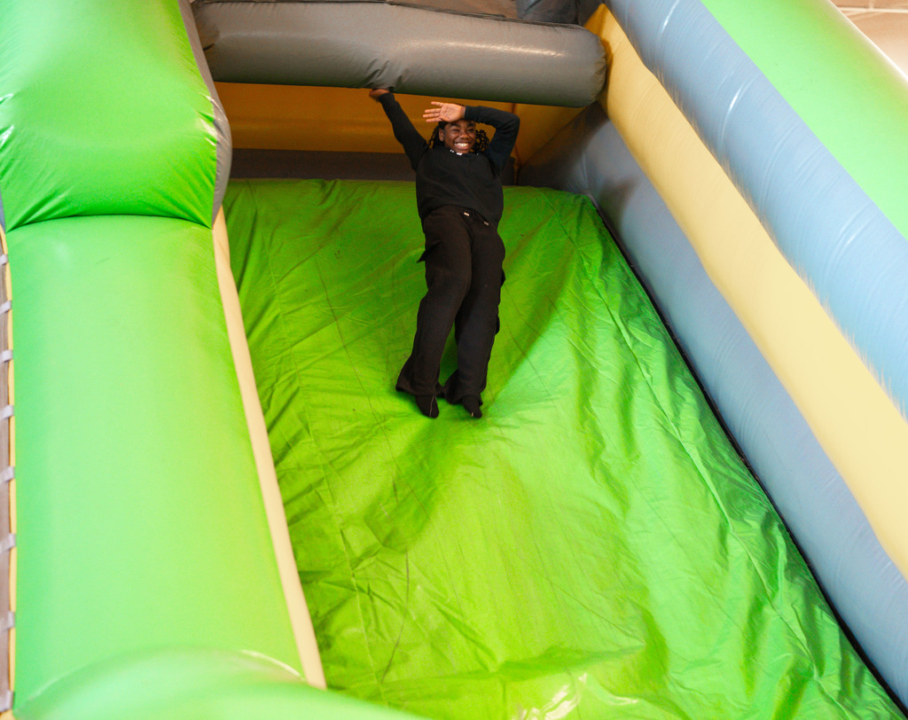 student sliding down an inflatable sign.