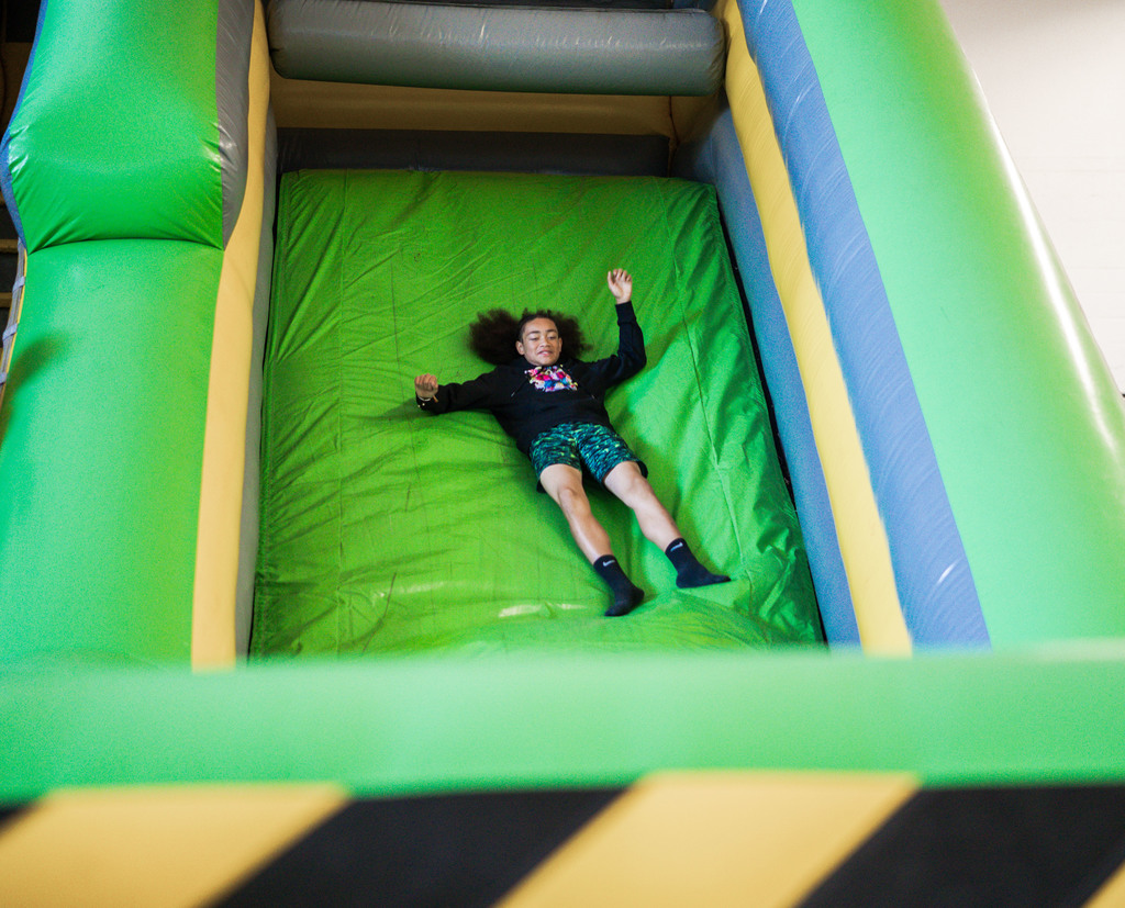 student sliding down an inflatable sign.