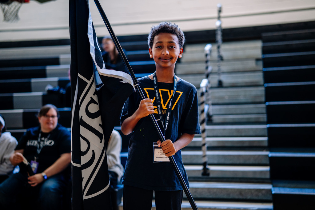 one of the house leaders holding their house flag.