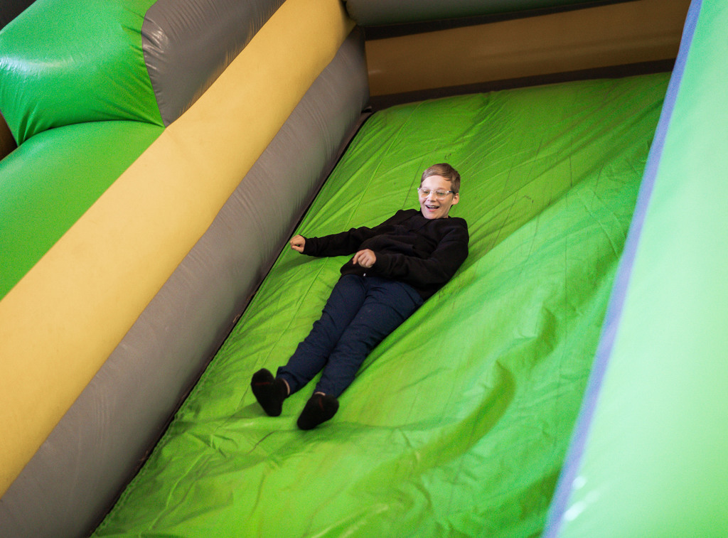 student sliding down an inflatable sign.