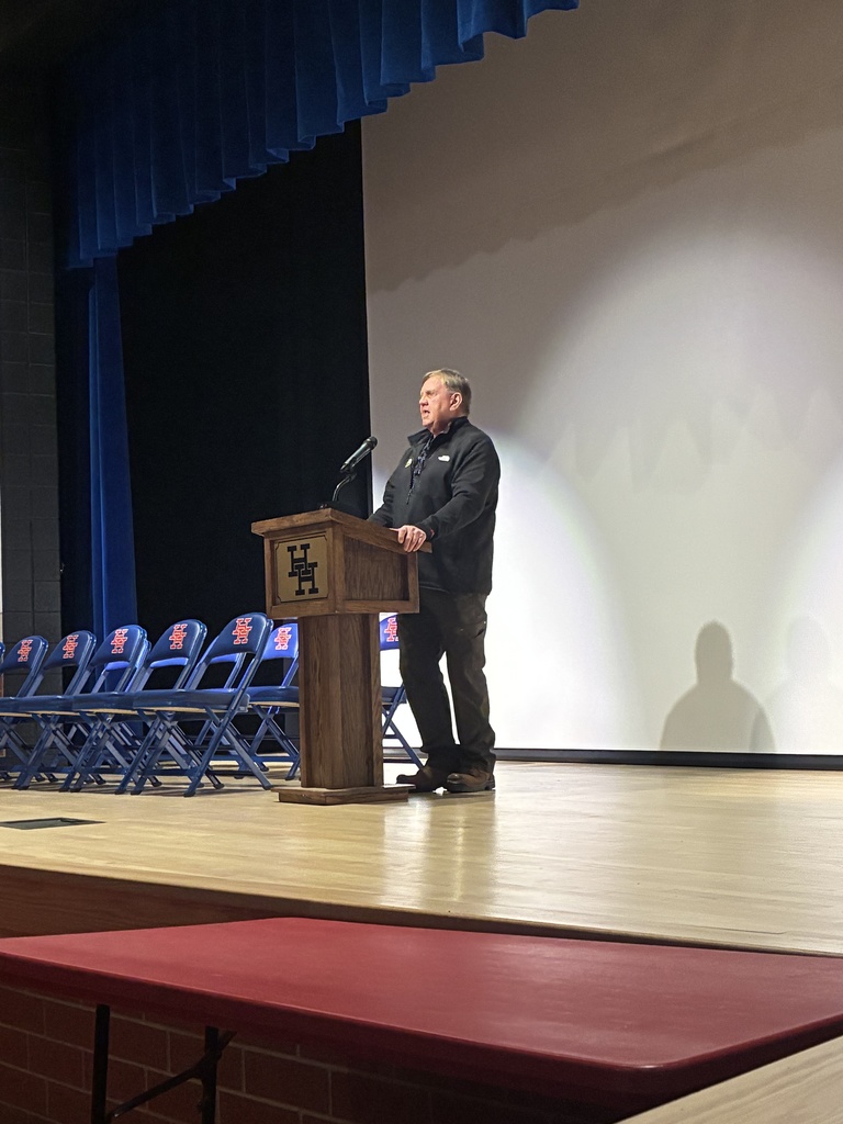 local contractor jerry hinzman speaking to shop students at the podium in the herbert hoover high school auditorium.
