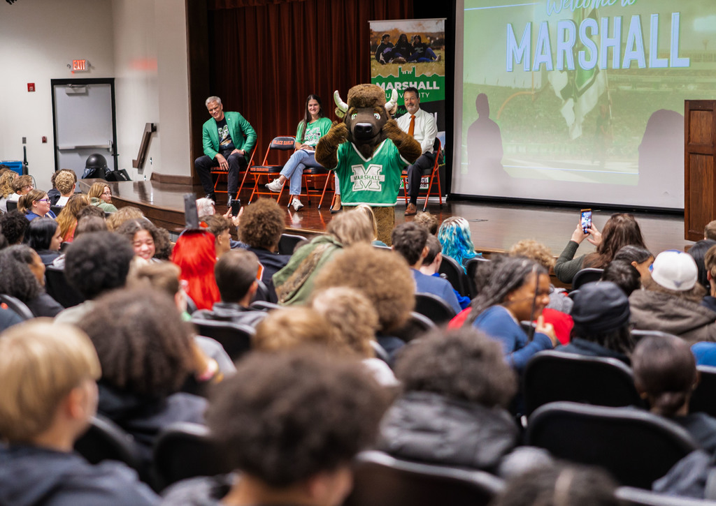 Marshall University mascot, marco, waving to students while walking into the south charleston high school auditorium at the end of the event.