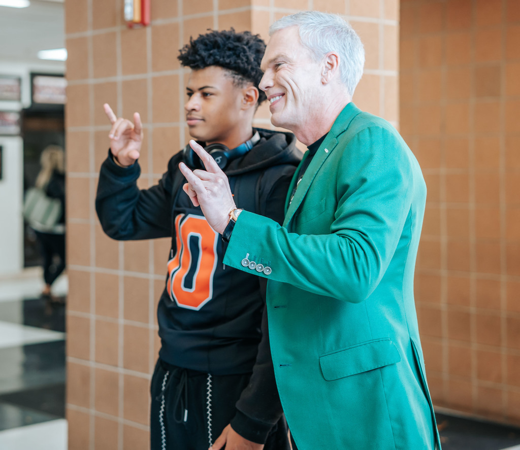  Marshall University President Brad Smith and a south charleston high school student giving the horns up sign while taking a picture together.